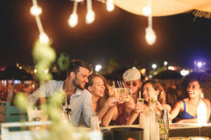 Young adults laughing at an outdoor bar