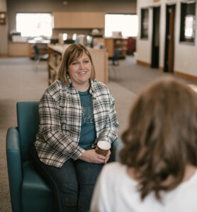 two women talking in a library